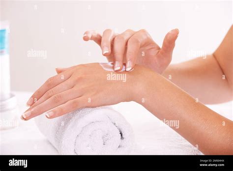 Keeping Her Hands Silky And Soft A Woman Applying Lotion To Her Hands