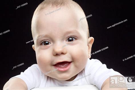 Portrait Of Happy Baby Boy Against Black Background Stock Photo