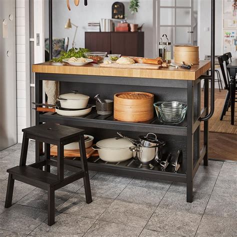 A repurposed wood top and shiplap sides completes the cabinet with farmhouse style. Ikea Vadholma Kitchen Island Hack