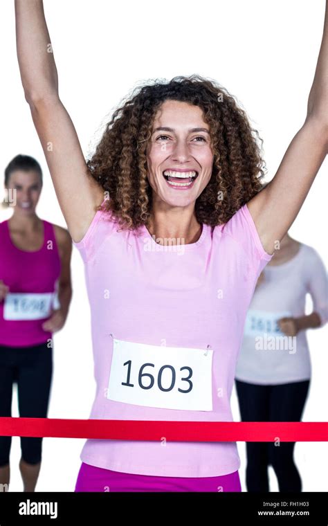 Smiling Winner Female Athlete Crossing Finish Line With Arms Raised