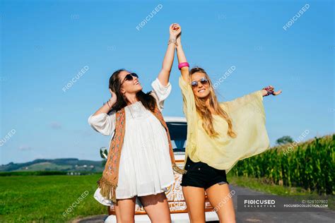 Deux Jolies Et Heureuses Filles Caucasiennes Vêtues De Vêtements Dété Debout Sur La Route à L