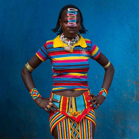 A Woman In Colorful Clothing Standing With Her Hands On Her Hips
