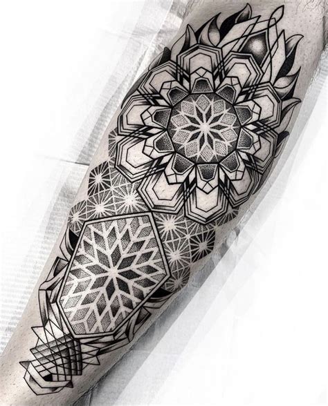 A Black And White Tattoo With Geometric Designs On The Forearm Hand