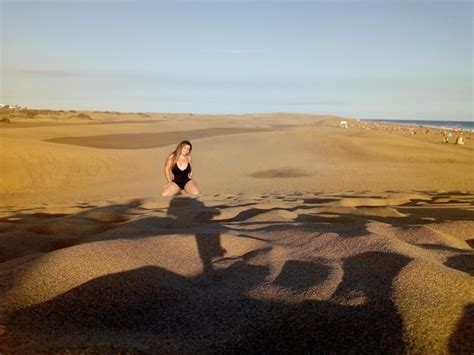 Premium Photo Woman Kneeling On Sand At Beach Against Sky