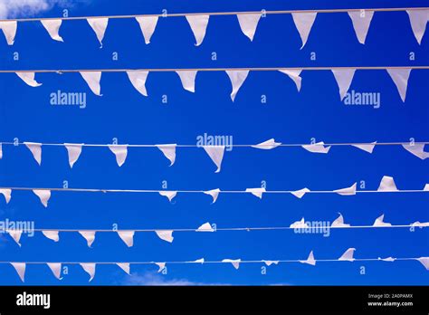 White Triangular Flags Waving In Wind Blue Sky Background Close Up