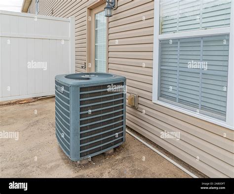 Horizontal Shot Of An Air Conditioning Unit On The Patio Behind A Condo