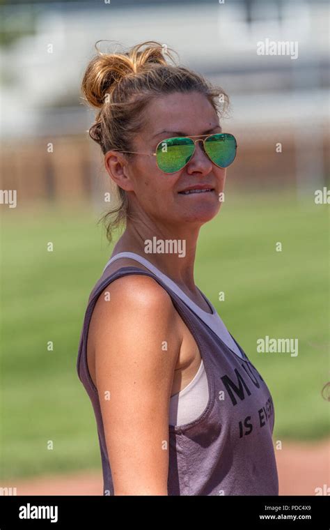 attractive woman in sunglasses and wearing tank top hair up in bun looking at camera profile
