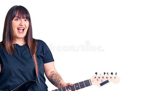 Young Plus Size Woman Playing Electric Guitar Screaming Proud