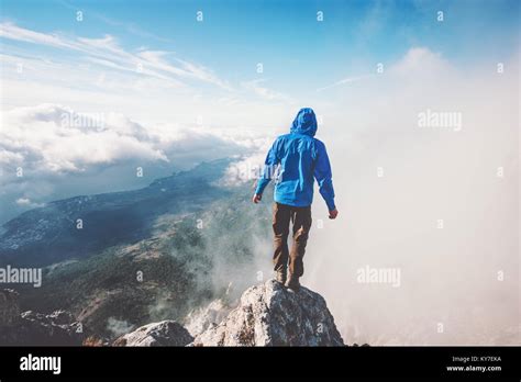 Man Traveler On Mountain Cliff Enjoying Aerial View Over Clouds Travel