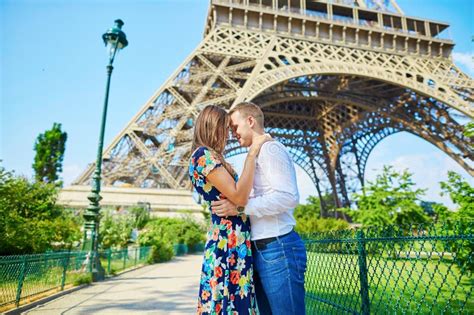 Young Romantic Couple Kissing Under The Eiffel Tower Stock Image