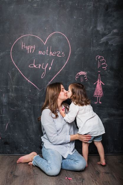 Madre E Hija Besándose Cerca De La Inscripción Feliz Día De La Madre