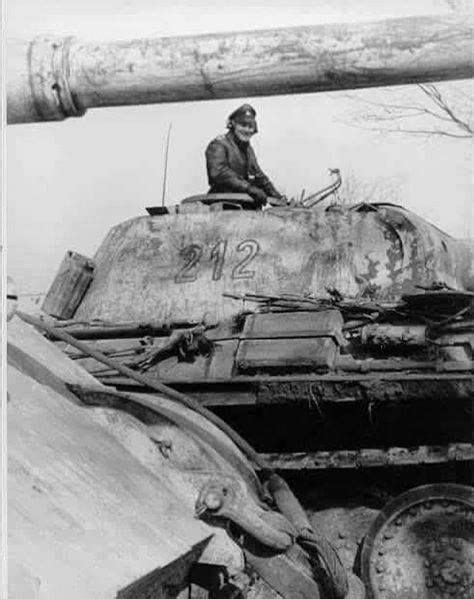 An Old Photo Of A Man Sitting On Top Of A Tank