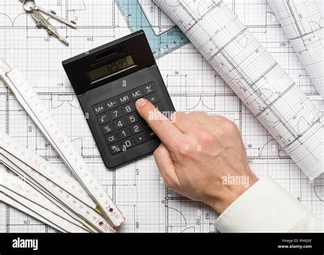 Architect Using Calculator On Architectural Blueprint House Building