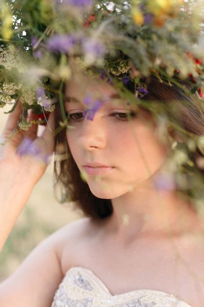 Premium Photo Beautiful Woman With A Wreath On Her Head Sitting In A Field In Flowers The