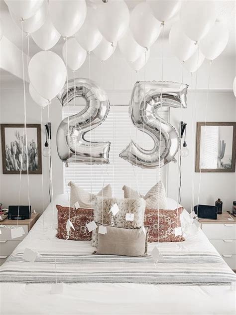 A Bed Topped With Lots Of White Balloons Next To A Wall Mounted Number