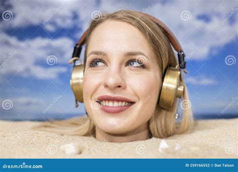 Woman Buried In Sand On Beach With Headphones Stock Photo Image Of