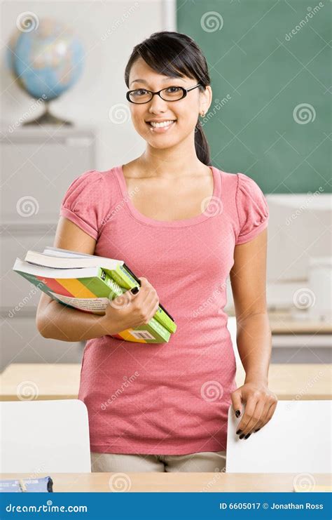 Female Teacher Holding Books In Classroom Stock Image Image Of