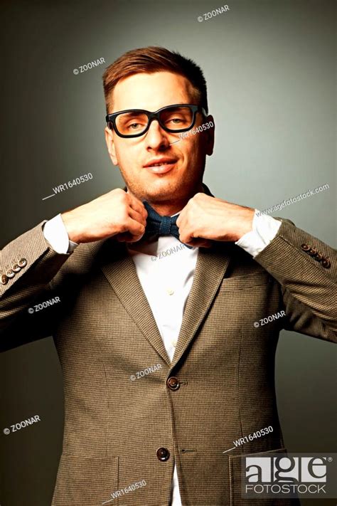 Confident Nerd In Eyeglasses Adjusting His Bow Tie Stock Photo