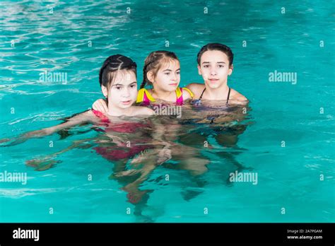 Three Girls Swim In The Pool Threesisters In The Pool Three Happy Girls Play In The Pool