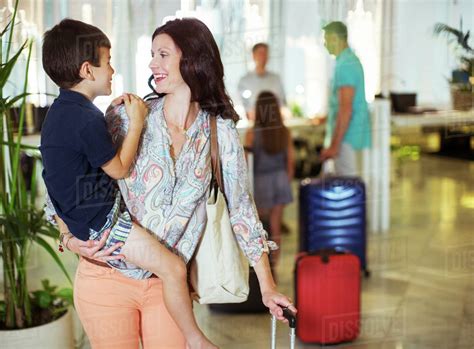Mother Carrying Son In Hotel Lobby Stock Photo Dissolve