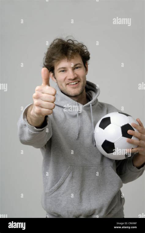 Young Man Holding Soccer Ball And Showing Thumbs Up Stock Photo Alamy