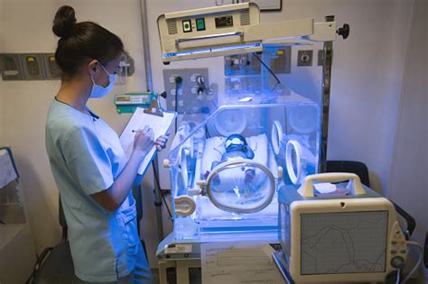 Nurse At The Neonatal Intensive Care Unit Checking Newborn Patient In