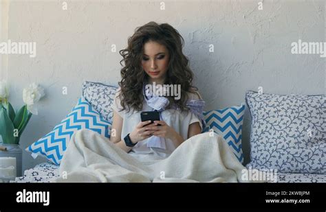 A Young Woman Communicate With A Friend On Her Mobile Phone After Waking Up Stock Video Footage