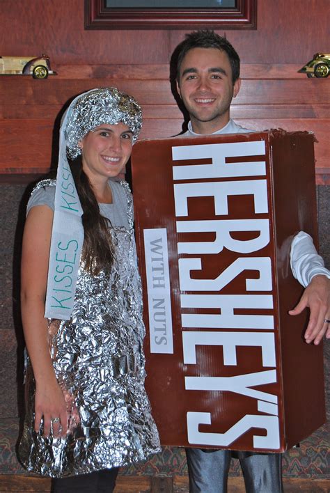 a man and woman dressed in tin foil holding a sign