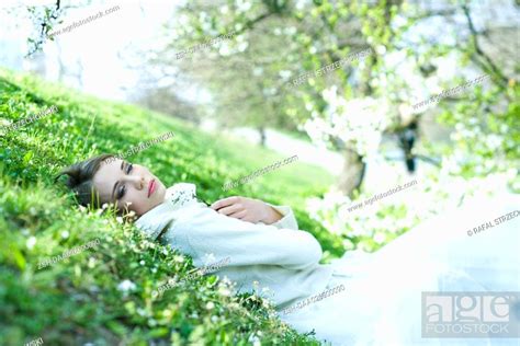 Teenage Girl Lying On The Ground Holding Flower Eyes Half Opened Stock Photo Picture And