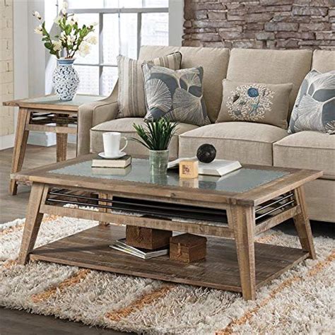 Chic and airy dining room is filled with rough hewn wood and chrome dining table surrounded by white stitched dining chairs placed in front of wall lined with fork scroll illuminated by polished nickel ring sconces. Riverside Furniture Coffee Table in Rough-Hewn Gray SALE ...