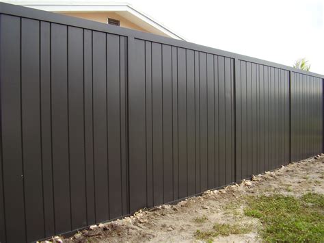 Using wide horizontal panels of corrugated metal, this fence relies on the dark wooden posts to stand strong. aluminum privacy fencing - Google Search | Backyard fences ...