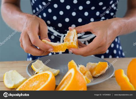 Woman Peeling Orange — Stock Photo © Wavebreakmedia 147240823