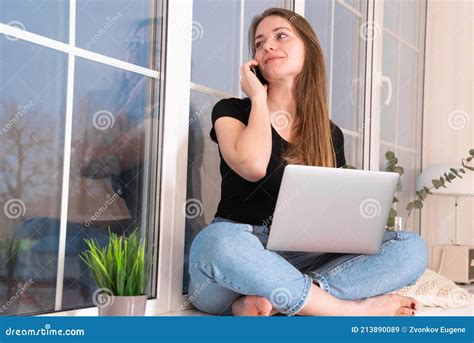 Girl Sitting With Crossed Legs And Working On Laptop Stock Image