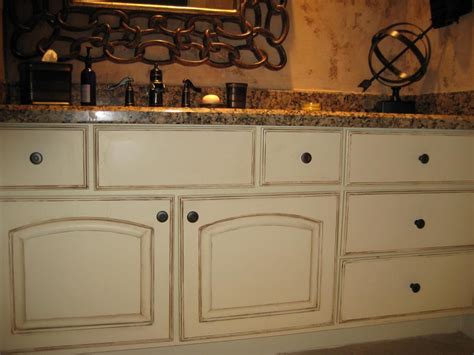 Distressing cabinet surface to achieve the antiquing look. painting cabinets | the never ending upkeep of painted ...