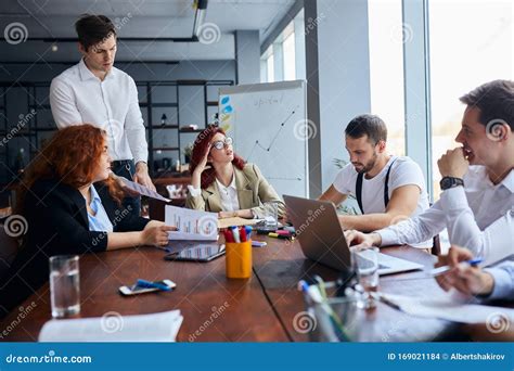 Happy Business People Gathered Around Table In Office Stock Photo