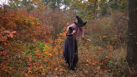 Young pink hair witch in hat search reagents in the mystical autumn 