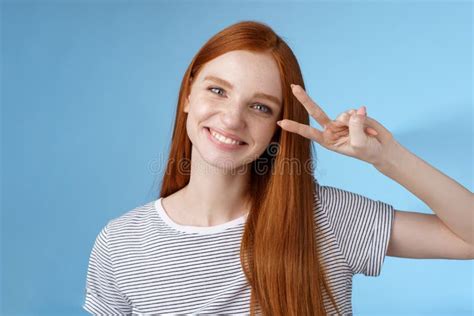 cheerful friendly gorgeous redhead girl glancing happily show peace victory sign tilting head