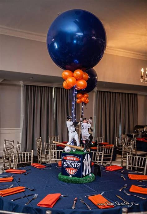an orange and blue balloon is on top of a table with sports themed centerpieces