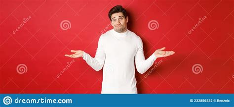 Portrait Of Clueless Handsome Guy Shrugging With Hands Spread Sideways