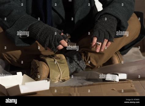 Partial View Of Homeless Man In Fingerless Gloves Holding Lighter And