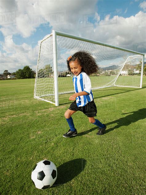 Mixed race girl playing soccer - Stock Photo - Dissolve