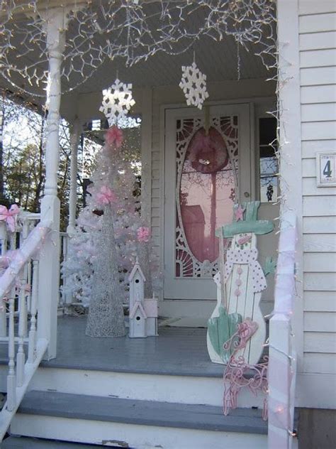 A Porch Decorated For Christmas With Pink And White Decorations On The Front Steps And