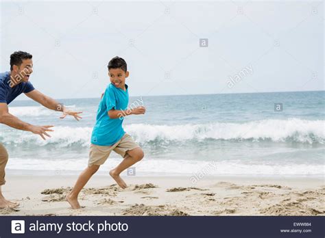 Father Running And Chasing Son On Beach Stock Photo Alamy