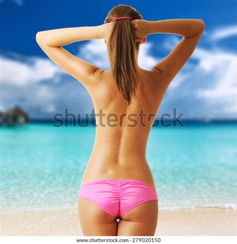 Una Mujer En Topless En Una Playa Tropical Con Agua Turquesa Cristalina