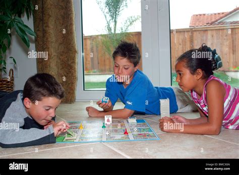 3 Multi Racial Kids Playing Board Game Indoor Inside On Floor Level
