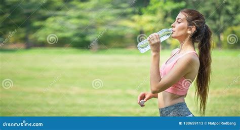 Young Fitness Woman Drinking Water From Plastic Bottle After Exercise