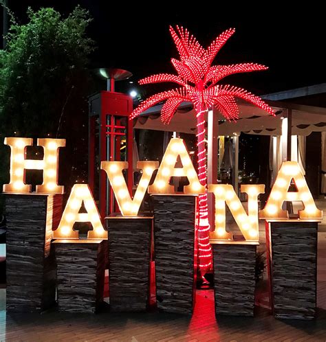 A Lighted Sign That Says Havana With A Palm Tree