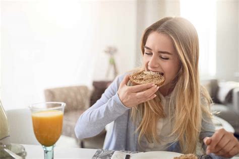 Close Up Of Young Woman Eating Breakfast At Home Stock Photo