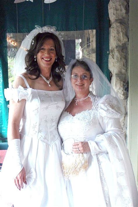two women in wedding dresses posing for a photo