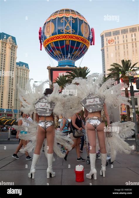 two women dressed as showgirls in las vegas the strip waiting to pose for pictures with tourists